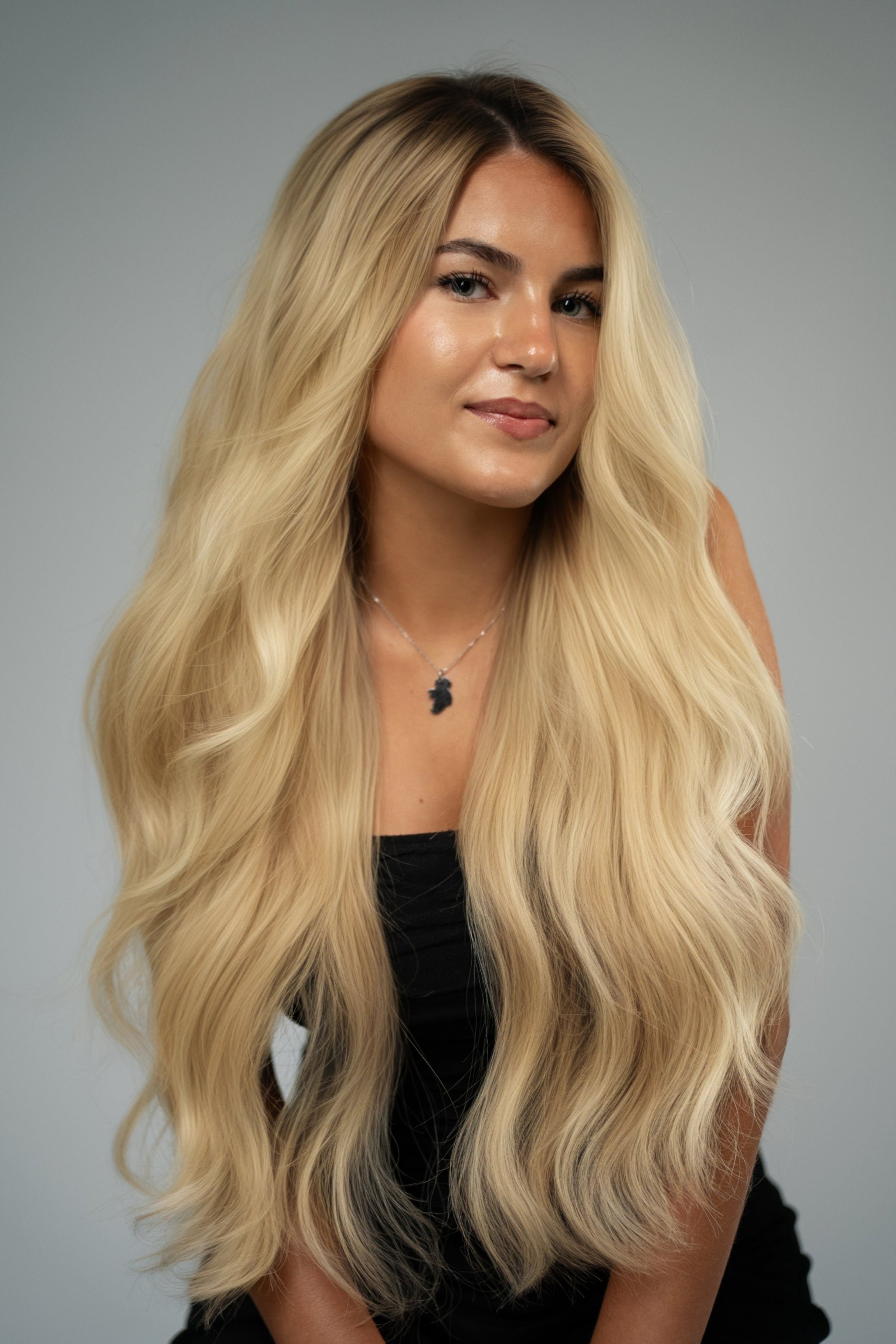 Woman with long blonde hair against a gray background